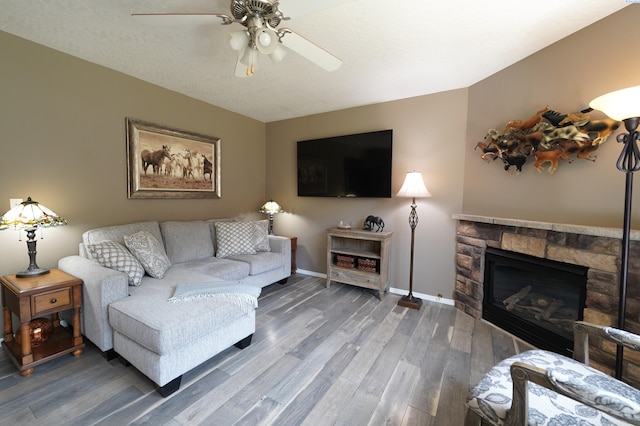 1135 SW Lost Trail Dr, Pullman, WA 99163 - living room featuring ceiling fan, wood finished floors, and a stone fireplace