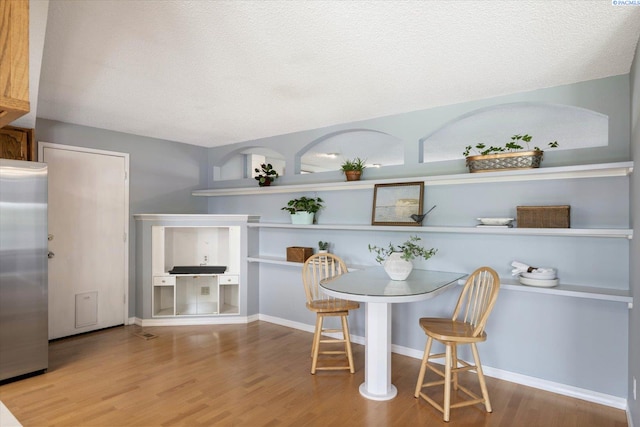 2714 W John Day Ave, Kennewick, WA 99336 - dining room featuring wood finished floors, a textured ceiling, and baseboards