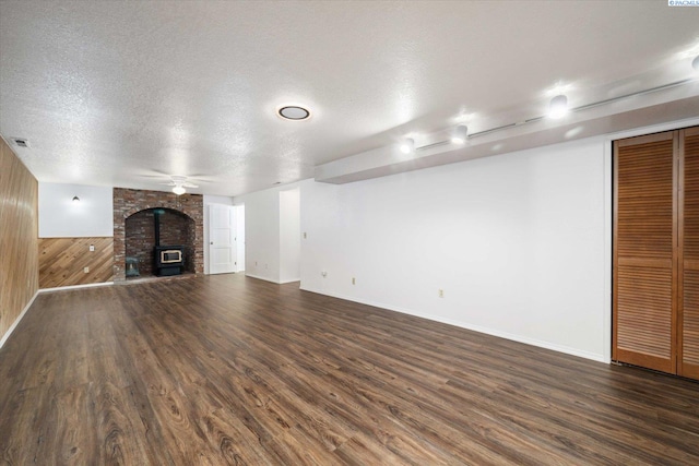 2714 W John Day Ave, Kennewick, WA 99336 - unfurnished living room with dark wood-style flooring, wooden walls, a textured ceiling, baseboards, and ceiling fan