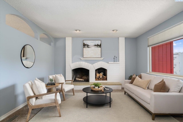 2714 W John Day Ave, Kennewick, WA 99336 - living area featuring carpet, a textured ceiling, a brick fireplace, and baseboards