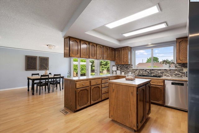 2714 W John Day Ave, Kennewick, WA 99336 - kitchen featuring stainless steel appliances, a sink, decorative backsplash, a kitchen island, and light wood-type flooring