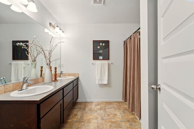 5725 Sidon Ln, Pasco, WA 99301 - full bathroom featuring double vanity, stone finish floors, baseboards, and a shower with curtain