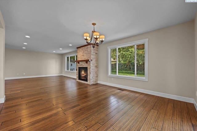 707 N Quillan St, Kennewick, WA 99336 - unfurnished living room featuring a chandelier, hardwood / wood-style floors, a fireplace, and recessed lighting