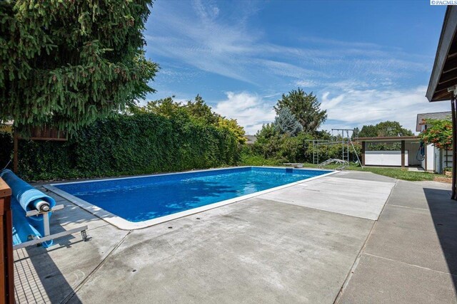 707 N Quillan St, Kennewick, WA 99336 - view of swimming pool with a patio area and a diving board