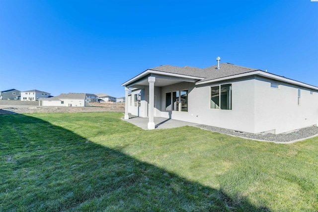 rear view of property with a lawn and a patio