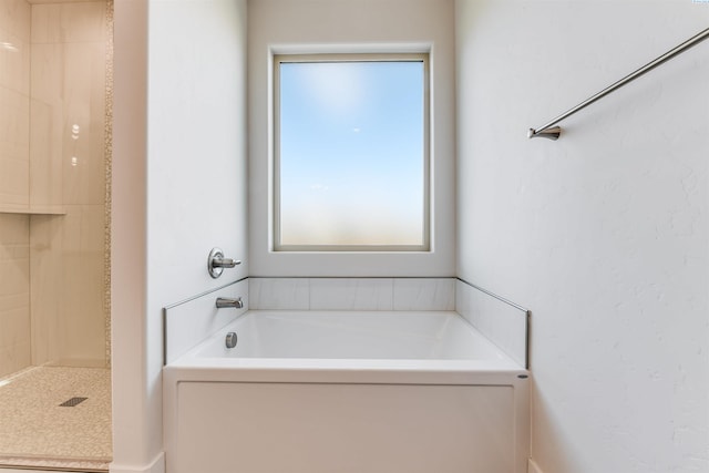 bathroom featuring plenty of natural light and plus walk in shower