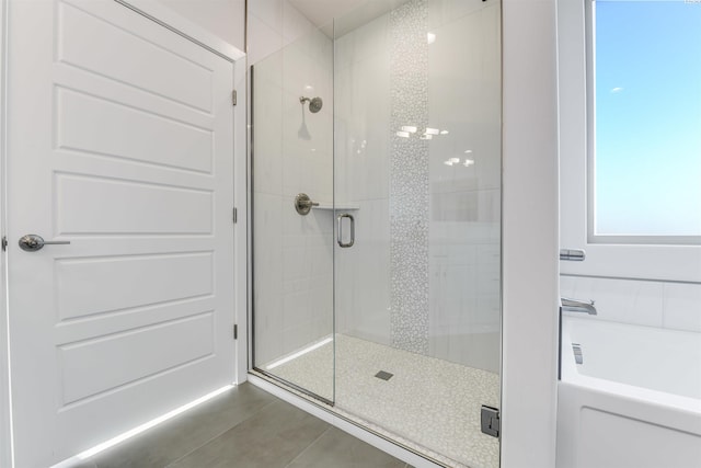 bathroom featuring tile patterned floors and separate shower and tub