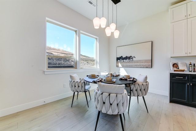 dining space featuring an inviting chandelier and light hardwood / wood-style floors