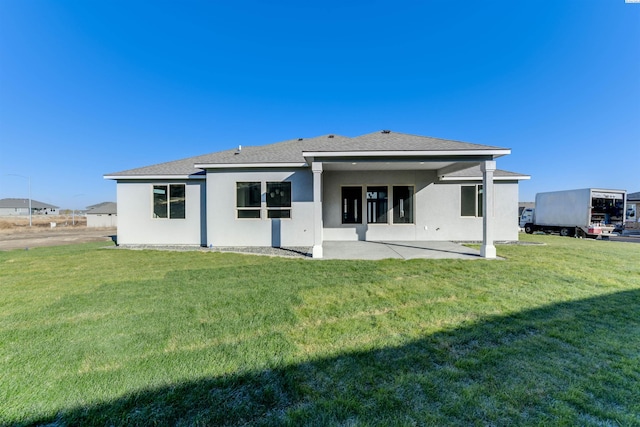 rear view of house with a yard and a patio area