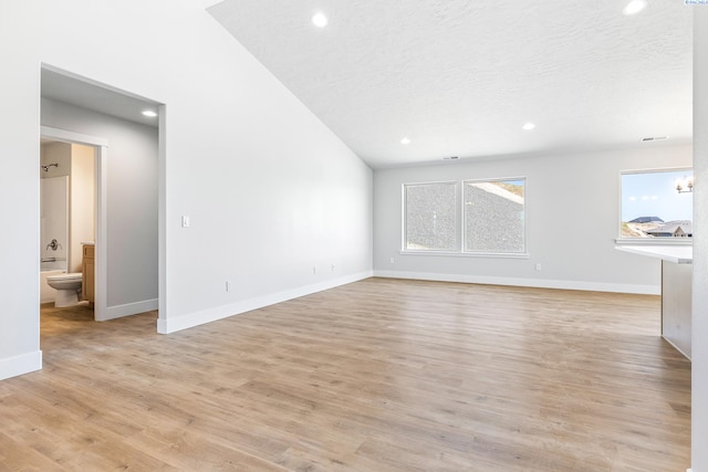 unfurnished living room featuring recessed lighting, baseboards, light wood-style floors, and a textured ceiling