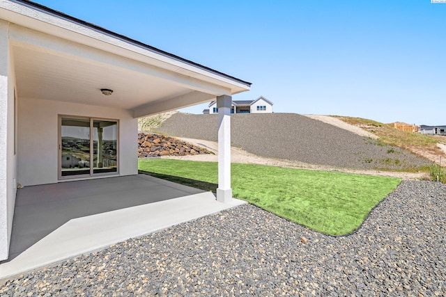 view of side of property with driveway, stone siding, and an attached garage