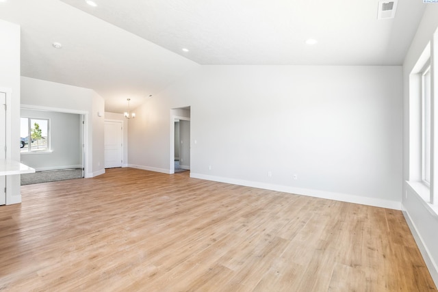 unfurnished living room with lofted ceiling, light wood finished floors, baseboards, a chandelier, and recessed lighting