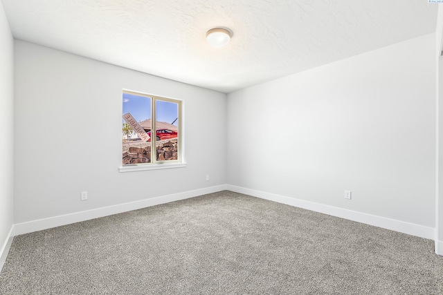 spare room with carpet and baseboards