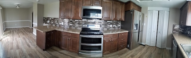 1529 Mcpherson Ave, Richland, WA 99352 - kitchen with light countertops, light wood finished floors, stainless steel appliances, baseboards, and decorative backsplash
