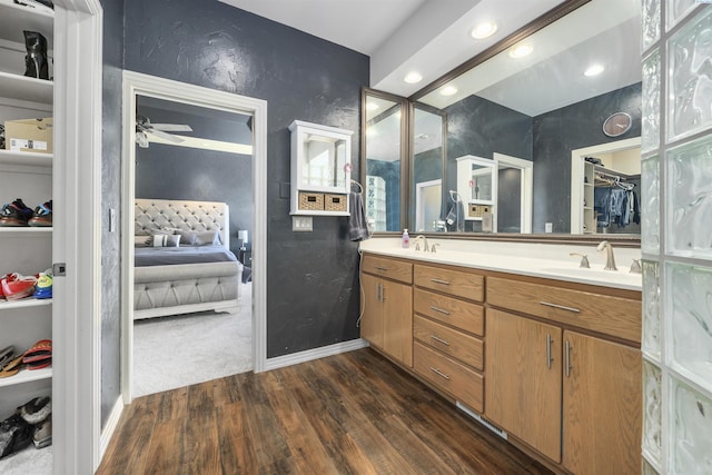 3501 W 42nd Ave, Kennewick, WA 99337 - bathroom with wood finished floors, double vanity, a walk in closet, baseboards, and a ceiling fan