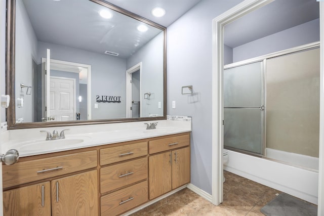 3501 W 42nd Ave, Kennewick, WA 99337 - bathroom featuring toilet, double vanity, combined bath / shower with glass door, and tile patterned floors