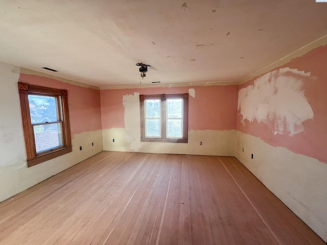 spare room with hardwood / wood-style flooring and a wealth of natural light