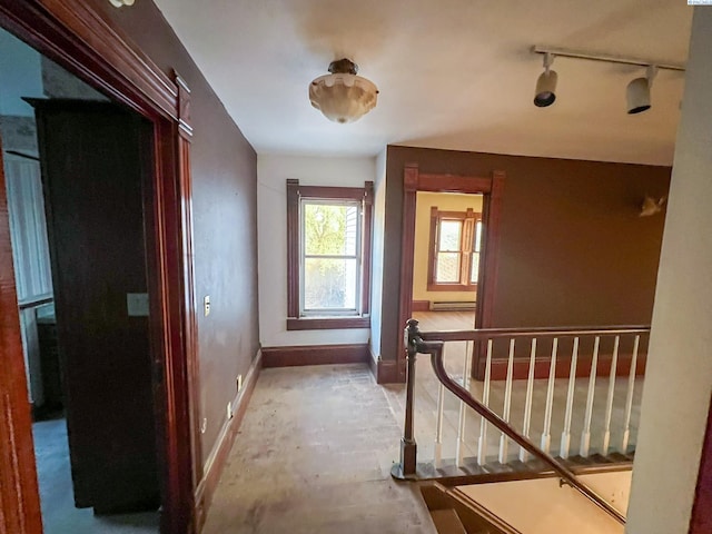 corridor with a baseboard radiator and track lighting