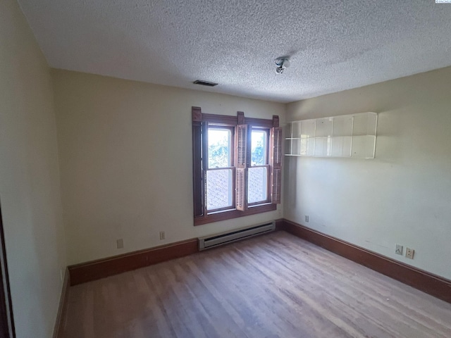 empty room featuring a baseboard radiator, a textured ceiling, and light hardwood / wood-style floors