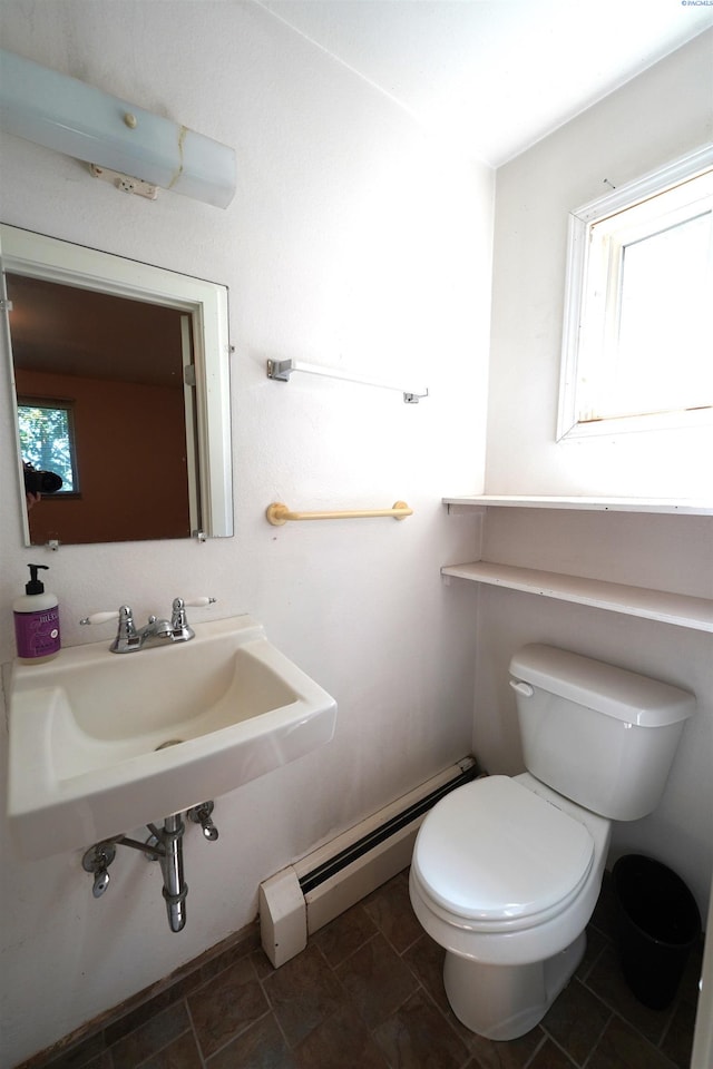 bathroom with a baseboard heating unit, sink, and toilet