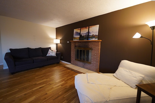 living room with dark hardwood / wood-style flooring, a fireplace, and a textured ceiling