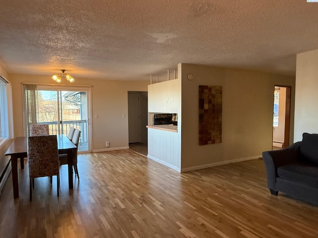 dining room featuring a notable chandelier, hardwood / wood-style flooring, and a textured ceiling