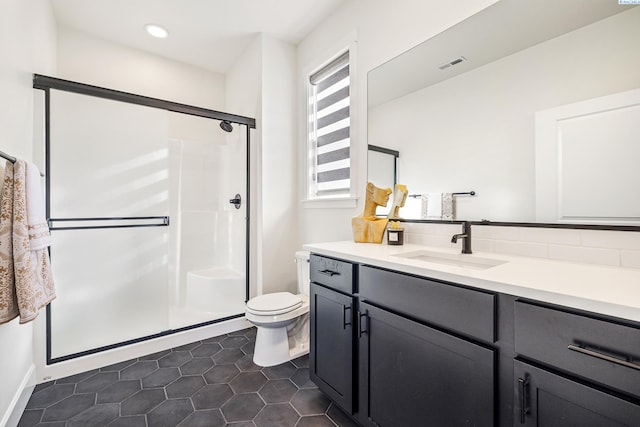 bathroom with visible vents, toilet, a stall shower, vanity, and tile patterned floors