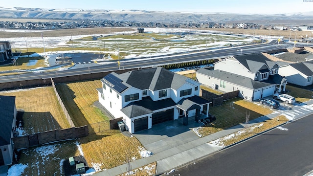 snowy aerial view featuring a residential view and a mountain view