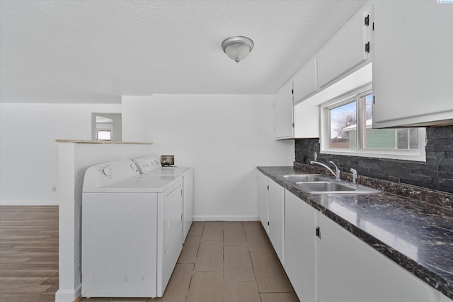 washroom with sink, cabinets, independent washer and dryer, and light wood-type flooring