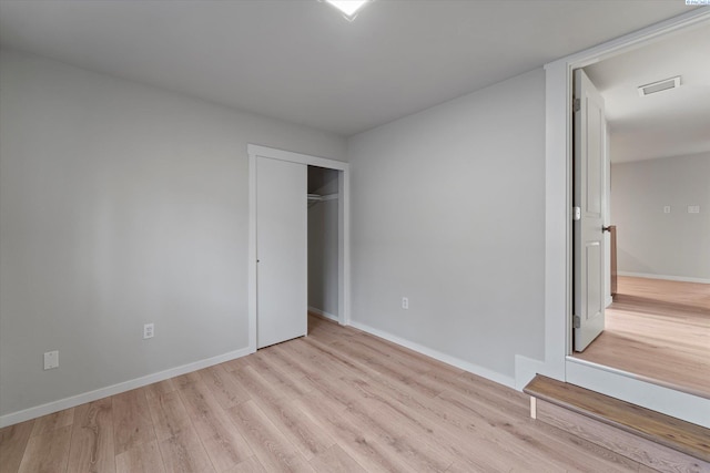 unfurnished bedroom with a closet, baseboards, and wood finished floors