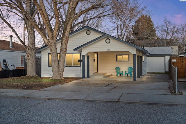 view of front of home featuring a garage, fence, and an outdoor structure