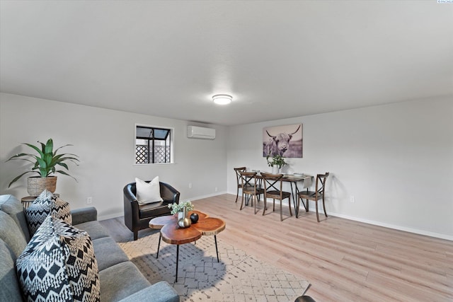 living area featuring a wall unit AC, light wood-style flooring, and baseboards