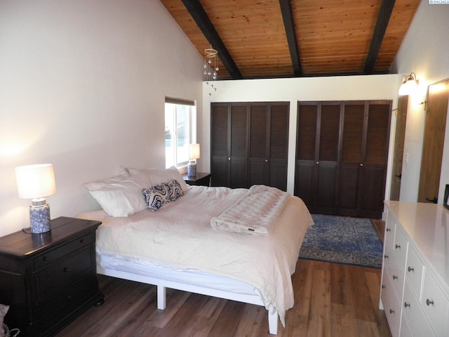 bedroom with beam ceiling, wooden ceiling, dark hardwood / wood-style floors, and multiple closets