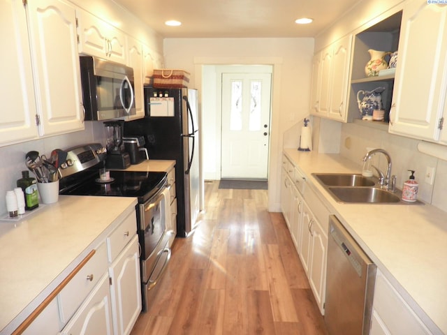 kitchen featuring white cabinetry, appliances with stainless steel finishes, sink, and light hardwood / wood-style flooring