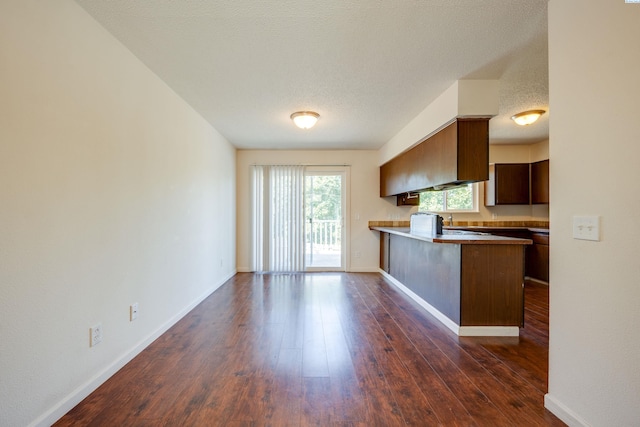 340-342 NW N St, Pullman, WA 99163 - kitchen with a textured ceiling, dark wood-style flooring, a peninsula, and baseboards