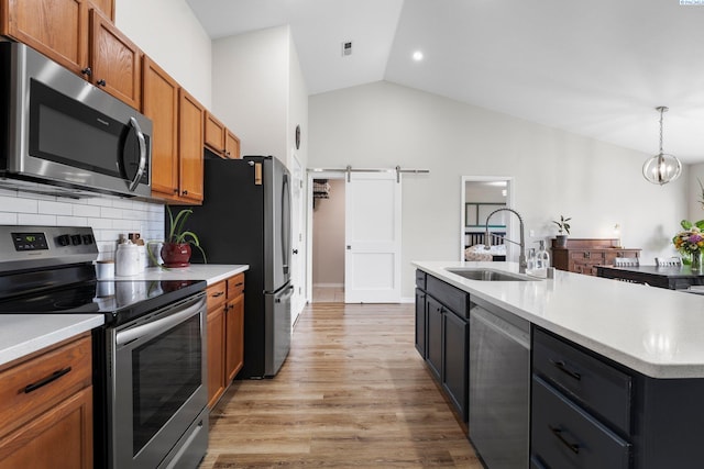 1707 W 25th Pl, Kennewick, WA 99337 - kitchen featuring stainless steel appliances, a sink, lofted ceiling, brown cabinetry, and backsplash
