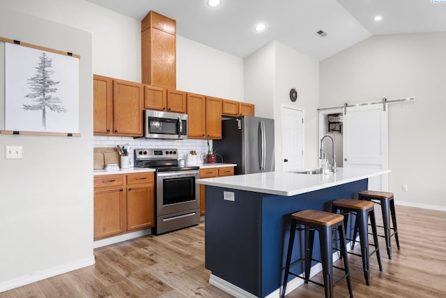 1707 W 25th Pl, Kennewick, WA 99337 - kitchen featuring stainless steel appliances, a sink, a barn door, backsplash, and baseboards