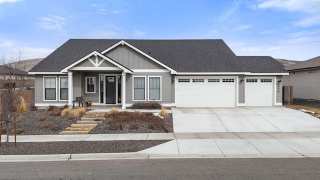 view of front of house with an attached garage, driveway, board and batten siding, and roof with shingles