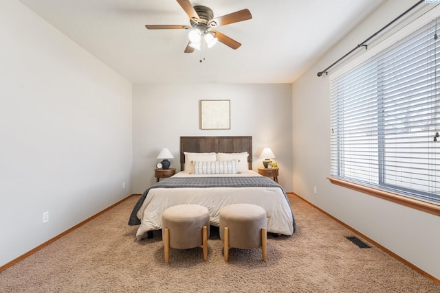 bedroom featuring a ceiling fan, baseboards, visible vents, and carpet flooring