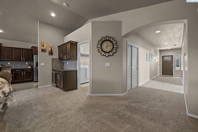 kitchen featuring stainless steel fridge with ice dispenser, open floor plan, light colored carpet, and independent washer and dryer