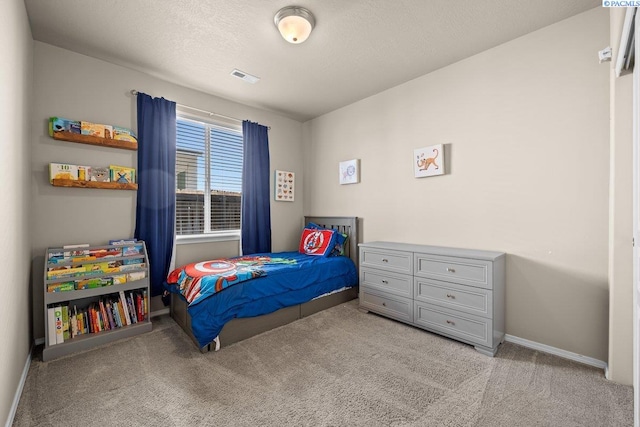 carpeted bedroom with baseboards, visible vents, and a textured ceiling