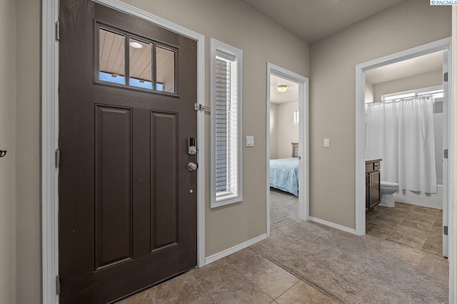 carpeted entrance foyer featuring baseboards