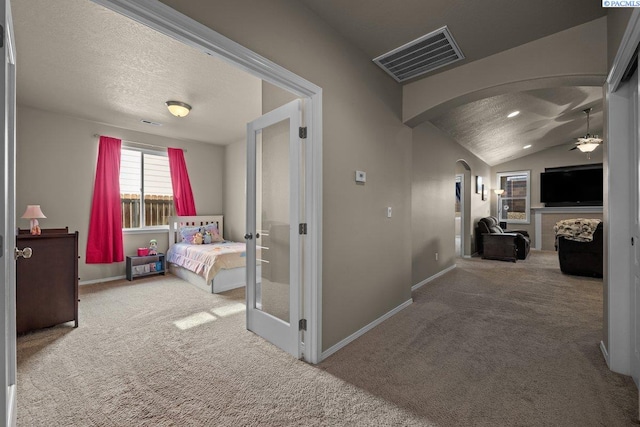 hallway featuring arched walkways, visible vents, carpet flooring, vaulted ceiling, and baseboards