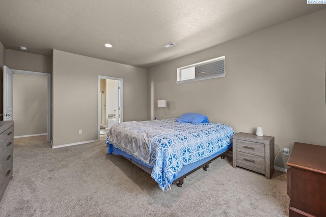 bedroom with carpet floors, visible vents, ensuite bathroom, a textured ceiling, and baseboards