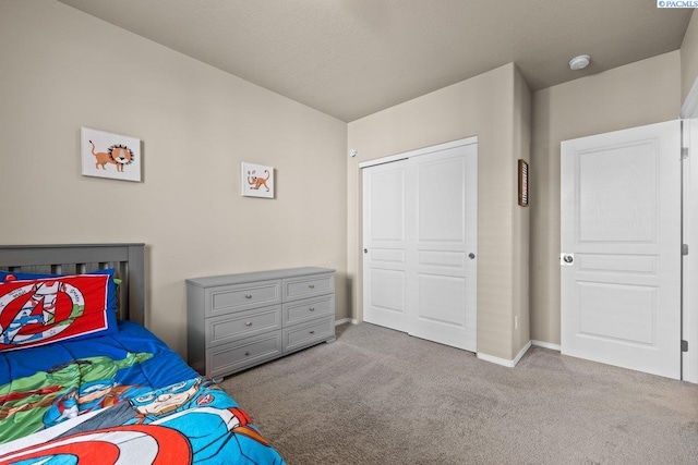 bedroom with carpet, a closet, and baseboards