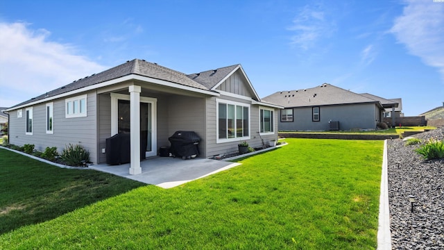 6012 W 31st Ave, Kennewick, WA 99336 - back of property featuring a patio, board and batten siding, and a lawn