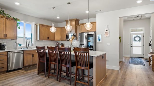 6012 W 31st Ave, Kennewick, WA 99336 - kitchen featuring stainless steel appliances, a sink, a kitchen island, light countertops, and backsplash