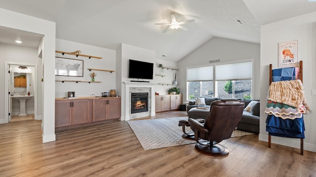 6012 W 31st Ave, Kennewick, WA 99336 - living room with a ceiling fan, light wood finished floors, a glass covered fireplace, baseboards, and high vaulted ceiling