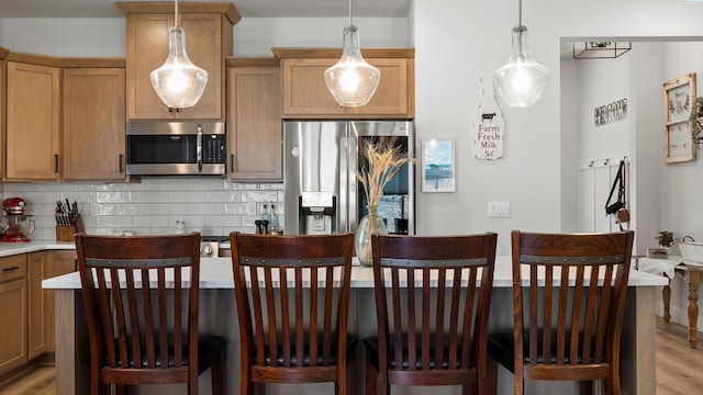 6012 W 31st Ave, Kennewick, WA 99336 - kitchen with appliances with stainless steel finishes, light wood-style floors, decorative backsplash, and light countertops