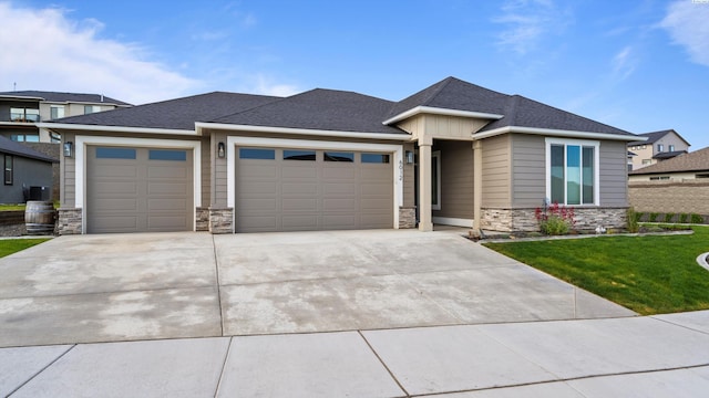 6012 W 31st Ave, Kennewick, WA 99336 - prairie-style house with stone siding, an attached garage, a front yard, driveway, and a shingled roof
